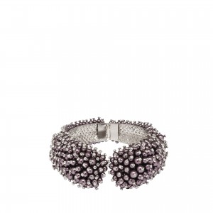 Ce pull, de la collection Balenciaga Automne-Hiver 2014, est construit comme un jeu d’origami. Pour plus d'élégance, la maille en laine et angora fusionne ici avec une soie duchesse drapée. Les éléments rebrodés reprennent l'aspect des oursins de mer avec une combinaison de tubes de verre, de perles et de strass. Inspirée à l'origine d'une broche des archives de Cristobal Balenciaga, la collection Automne Hiver 14-15 est truffée de cette broderie précieuse et sophistiquée que l'on retrouve sur les manchettes et colliers ponctuant les silhouettes.