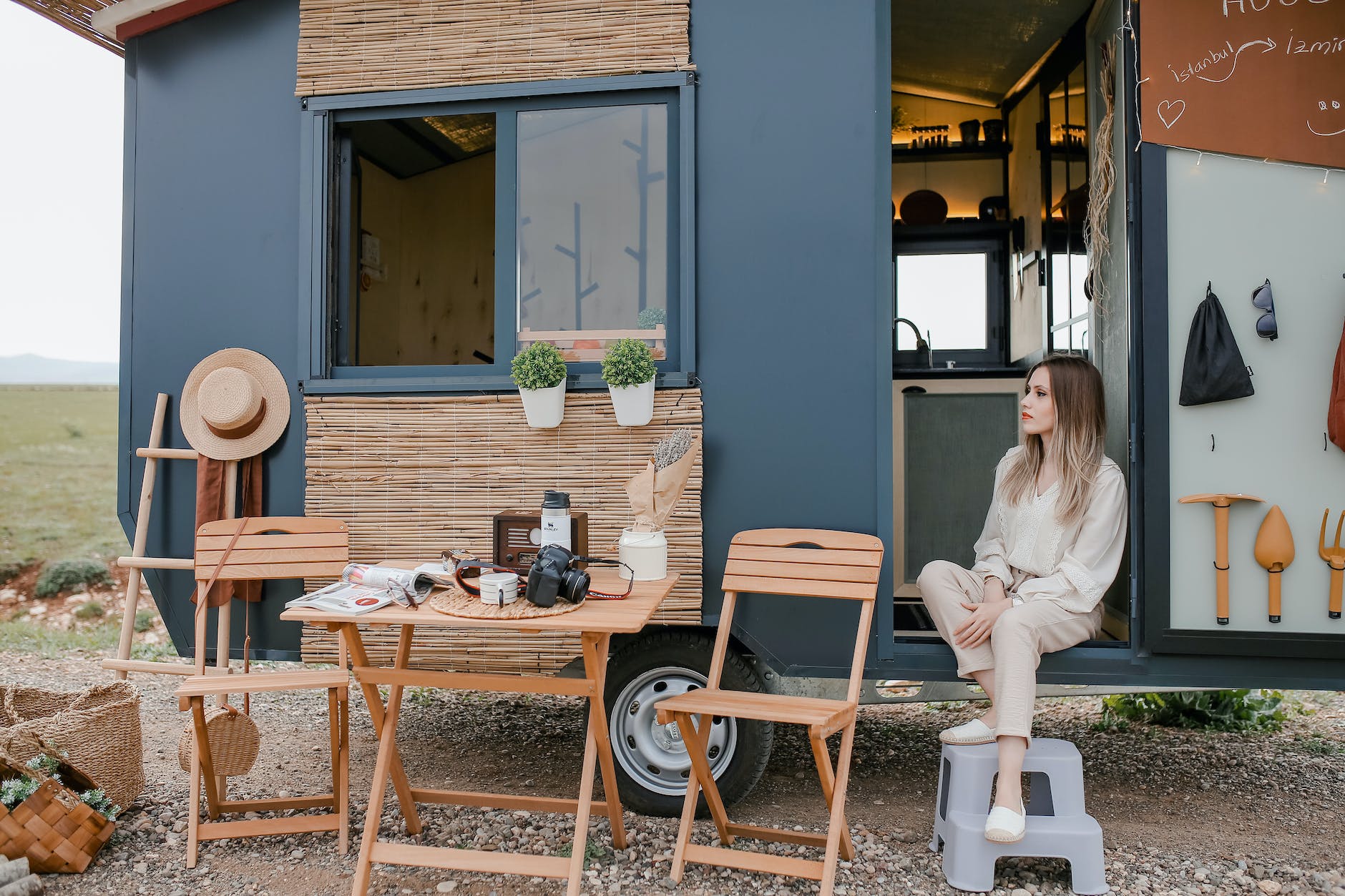 woman sitting in a trailer converted to a house on wheels