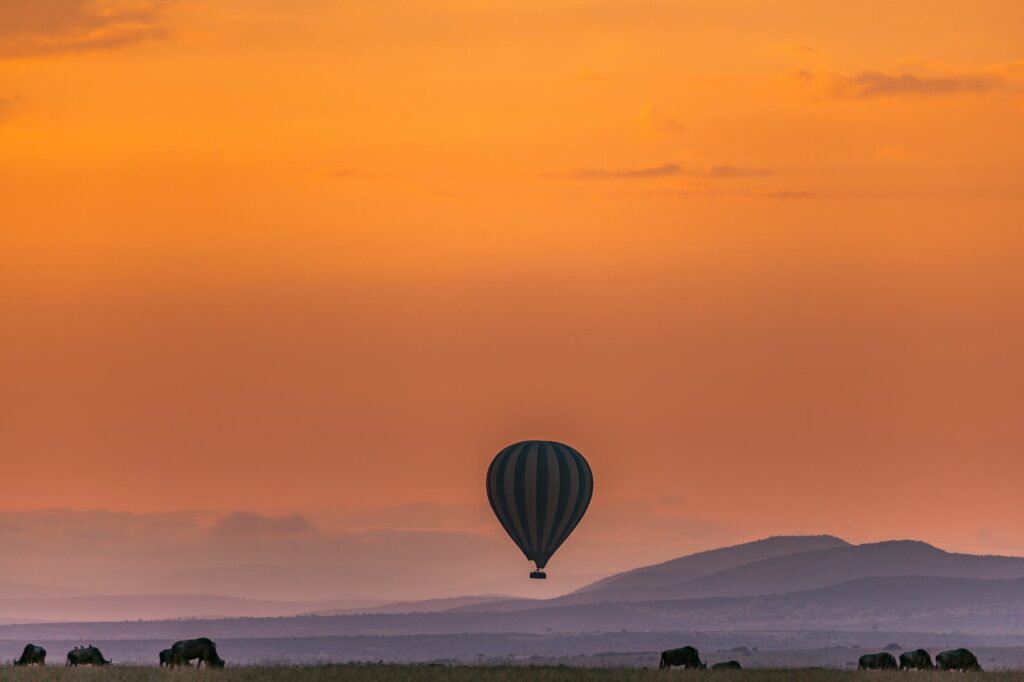 multicolored air balloon floating against amazing sunset