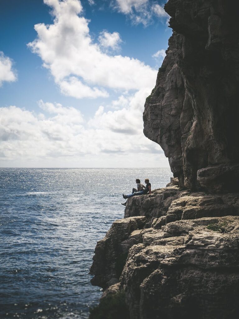 two people sitting by the cliff