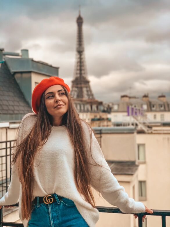 brunette woman in red beret posing against eiffel tower