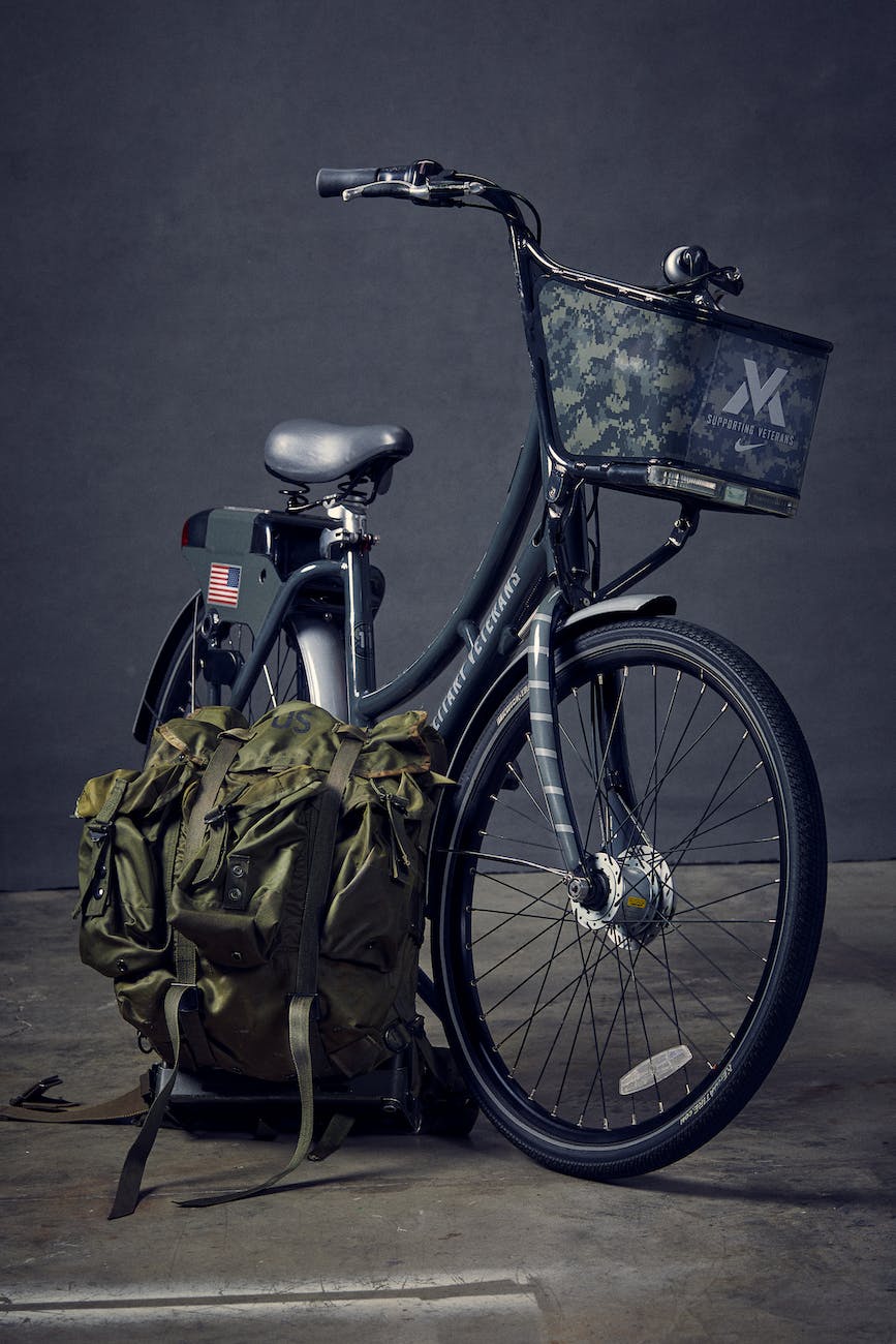black commuter bike beside green backpack