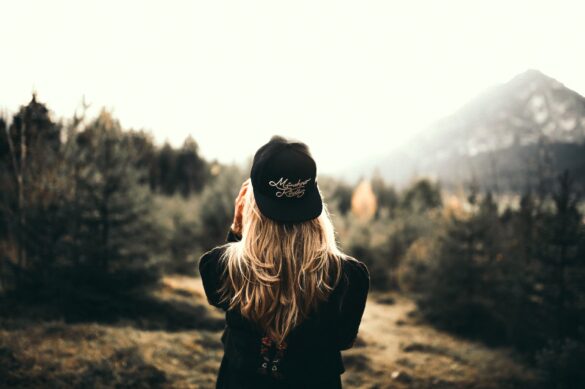 back view of a woman black sweater and black cap