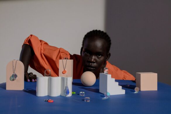 person sitting behind the table with fancy jewelry on display