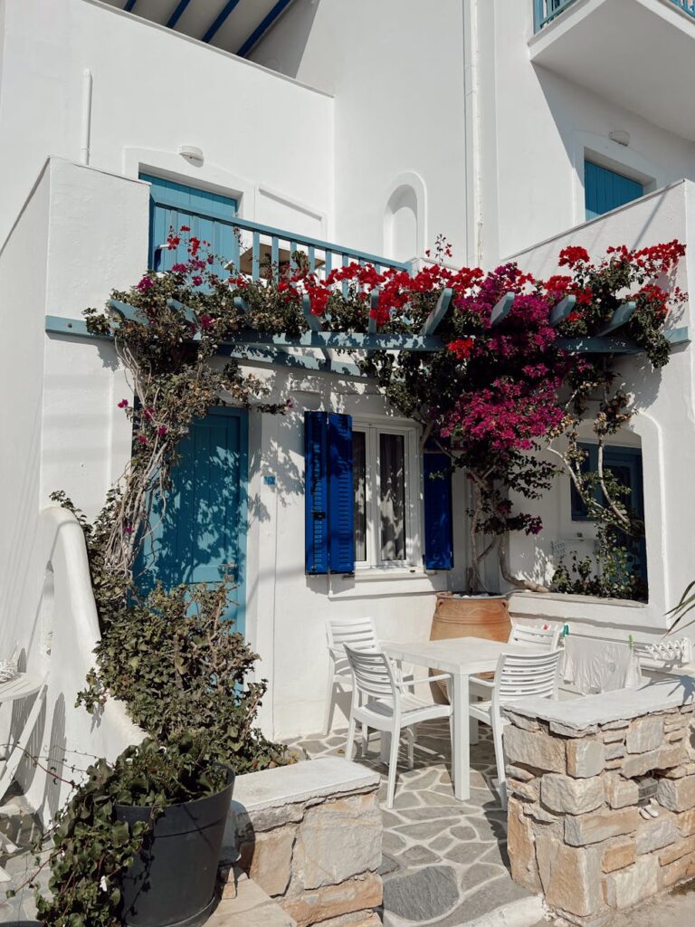 white wooden chairs and table near blue door