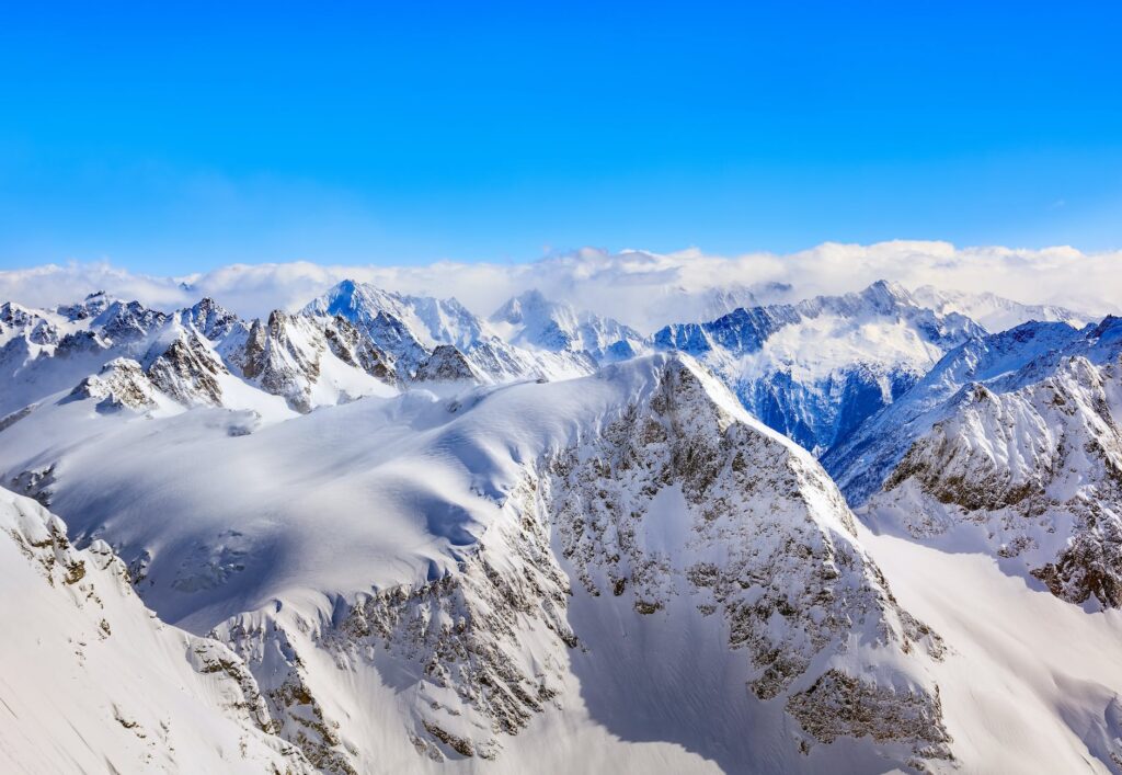 areal photography of snow coated mountains under clear blue sky