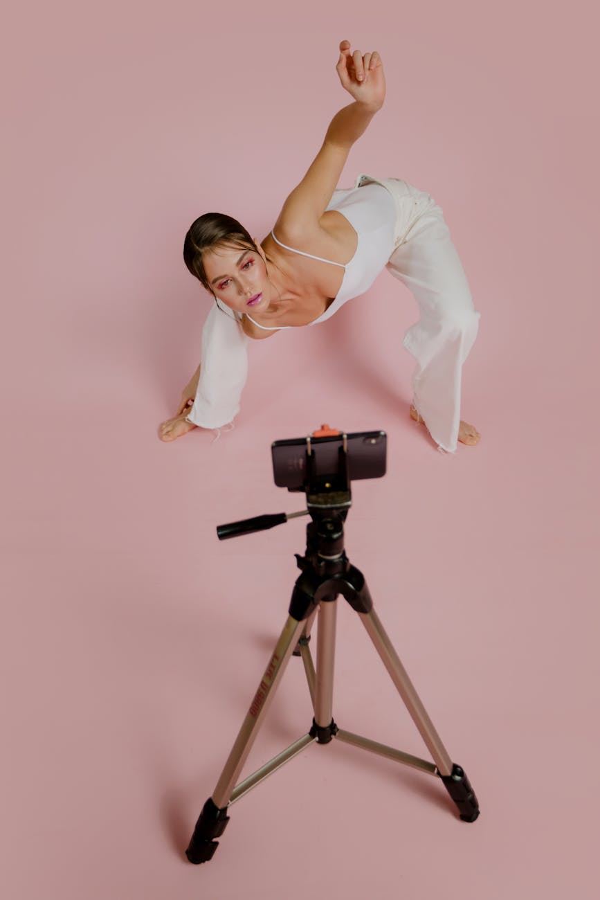 young woman posing in front of a smartphone on a tripod
