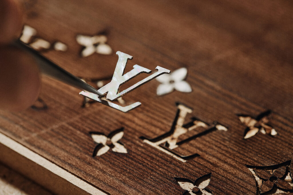 La vague comme grammaire masculine 117 LOUIS VUITTON MENrsquoS SPRING SUMMER 2027 NACRE MARQUETERY TRUNK 2