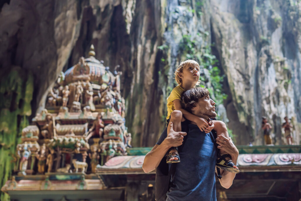 Ce que la Malaisie apprend aux familles qui refusent de choisir 30 Father and son in the background of Batu Caves near Kuala Lumpur Malaysia. Traveling with children concept